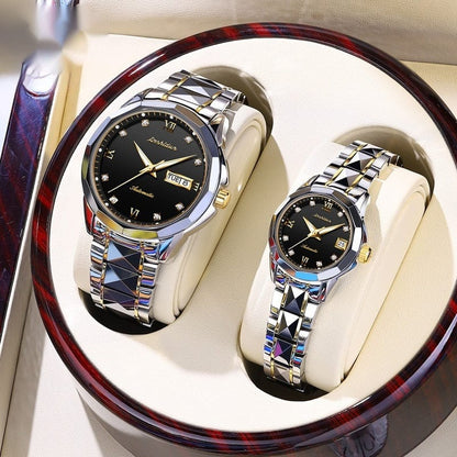 A pair of silver and gold-toned watches with black dials, crystal hour markers, and faceted metallic bands presented in a round, polished wooden display case.