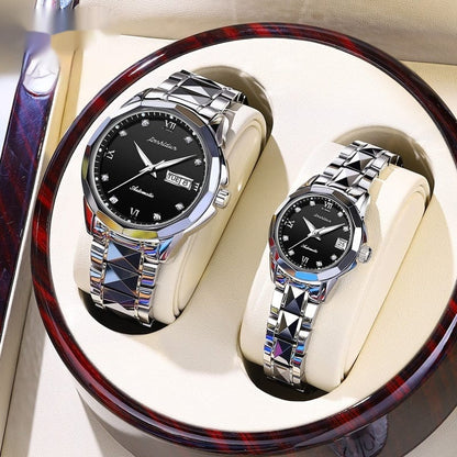 A pair of matching silver-tone automatic wristwatches with black dials, diamond-style hour markers, and unique geometric link bracelets displayed side-by-side inside a round wooden presentation box.