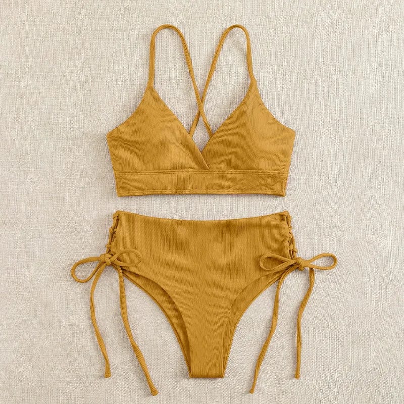 A mustard yellow bikini set featuring a ribbed bralette top with crisscross straps and high-waisted bottoms with lace-up side ties.