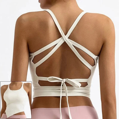 A white crop top worn by a person, featuring a crisscross strap design on the open back and a tie closure at the waist, with an inset showing the front view of the same tank top.