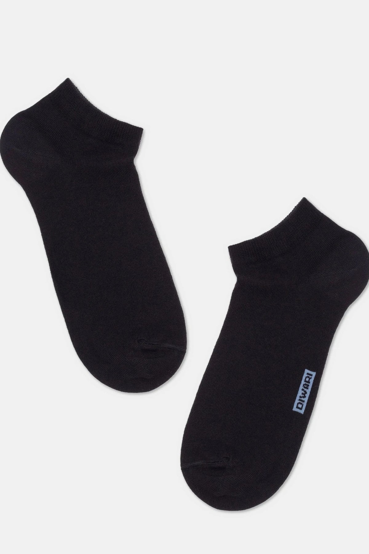 A pair of black ankle socks laid out on a light background, with a small blue logo tag visible on the side of one sock.