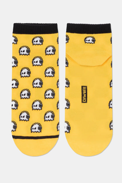 Ankle socks in yellow featuring a repeated pattern of white pixelated ghosts wearing black headphones, with a black brand label on the heel of the right sock.