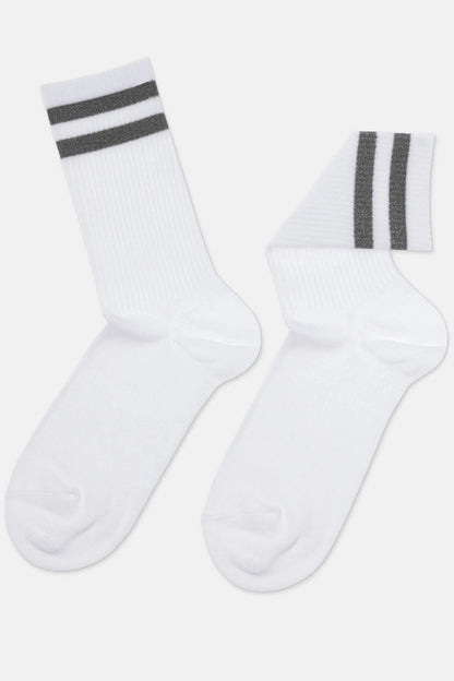 A pair of white crew-length socks featuring two horizontal grey metallic stripes near the ribbed cuffs against a plain background.