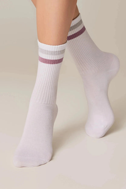 White ribbed crew socks featuring a silver and pink metallic striped detail on the cuffs, worn on the feet against a neutral background.
