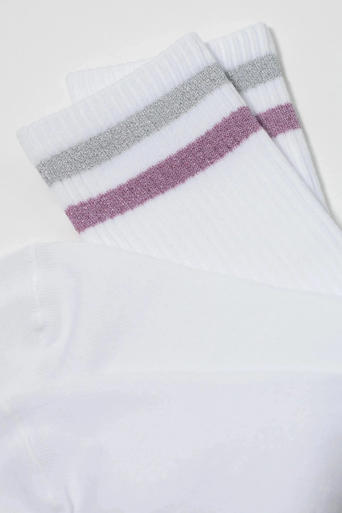 White crew socks feature a metallic silver stripe and a metallic pink stripe at the ribbed cuffs.