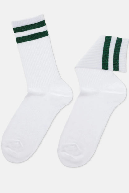 A pair of white crew-length socks featuring two horizontal glittery green stripes around the ribbed cuffs.