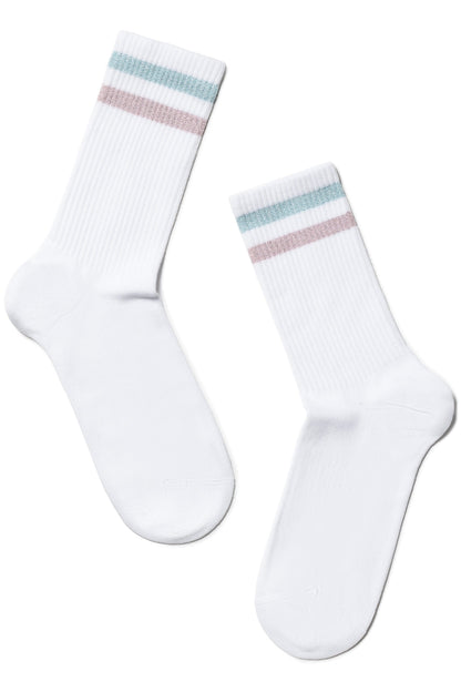 A pair of white crew-length athletic socks featuring two thin horizontal stripes in shimmering light blue and soft pink at the ribbed cuffs.