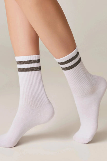 A pair of white ribbed mid-calf socks with two thin dark horizontal stripes featuring a subtle glitter finish on the cuffs.