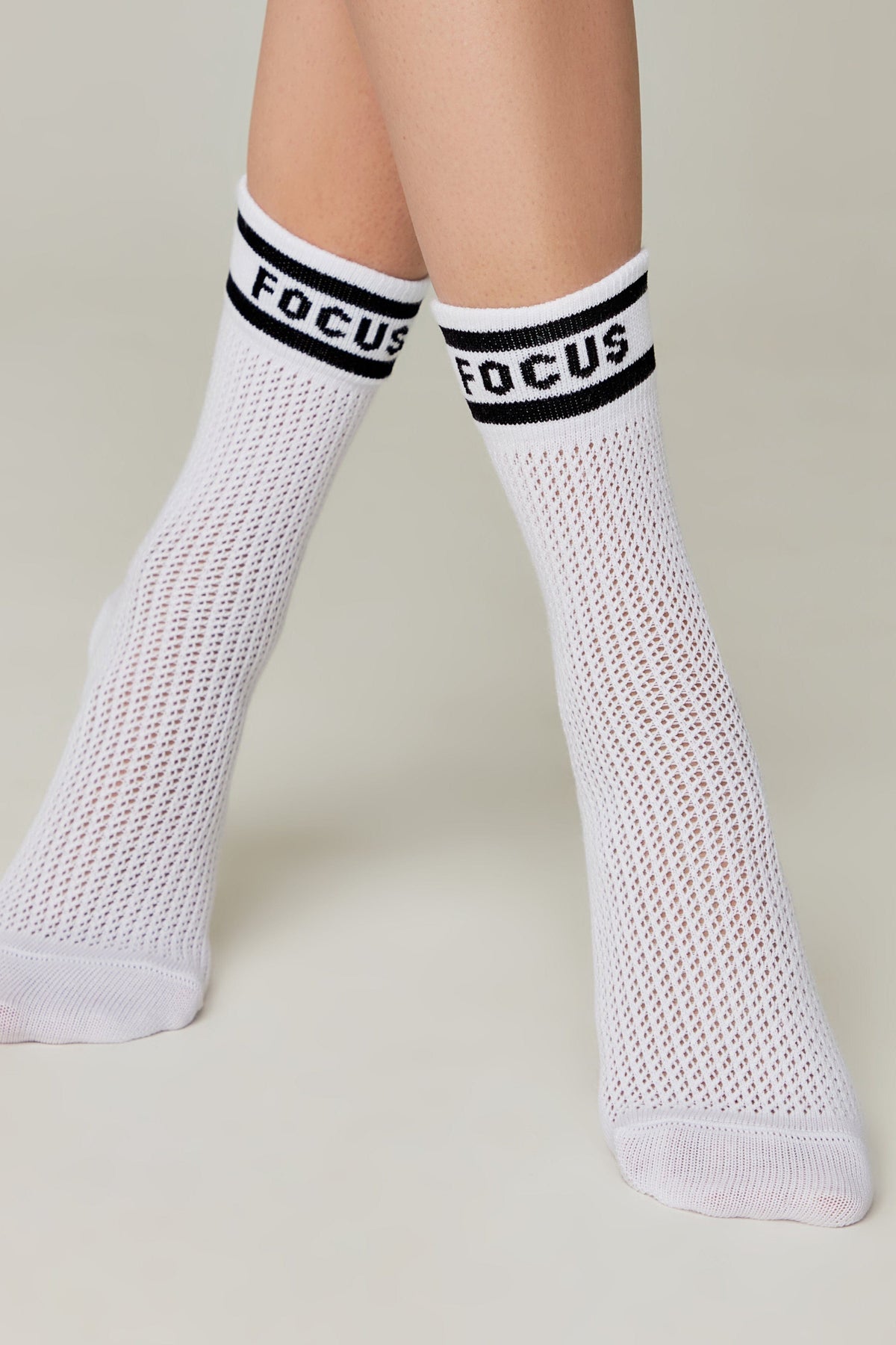 A pair of white mesh crew socks featuring a black horizontal stripe and the word FOCUS in bold black letters on the cuffs.