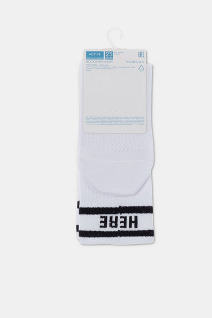 A pair of white crew-length socks featuring two black horizontal stripes at the cuff and the word 'HERE' printed in bold black capital letters near the bottom.