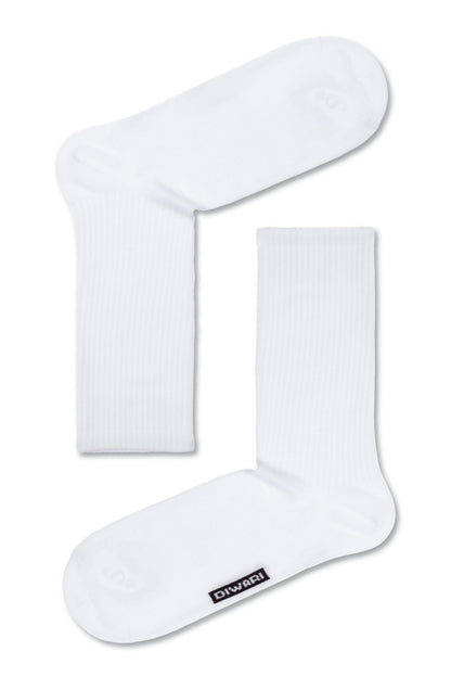 A pair of plain white ribbed socks displayed against a white background, with a small black brand logo tag on the side of one sock near the toe.