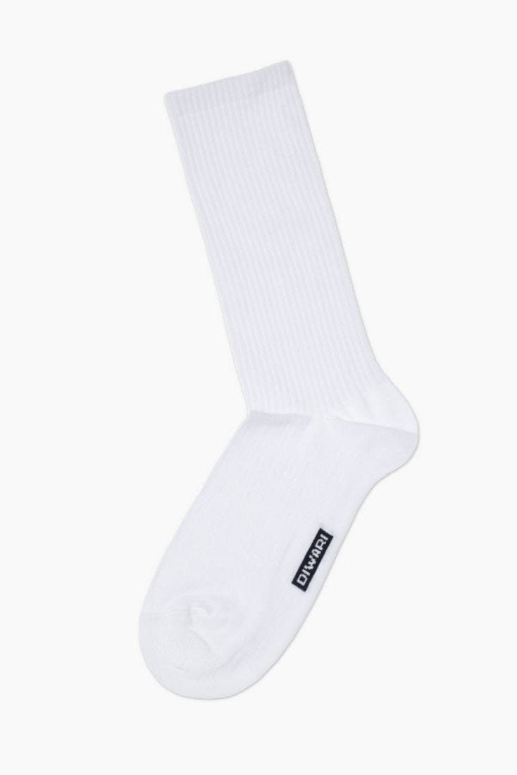 A plain white ribbed crew sock featuring a small black rectangular brand label on the side.