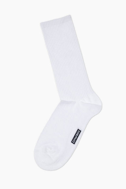 A plain white ribbed crew sock featuring a small black rectangular brand label on the side.
