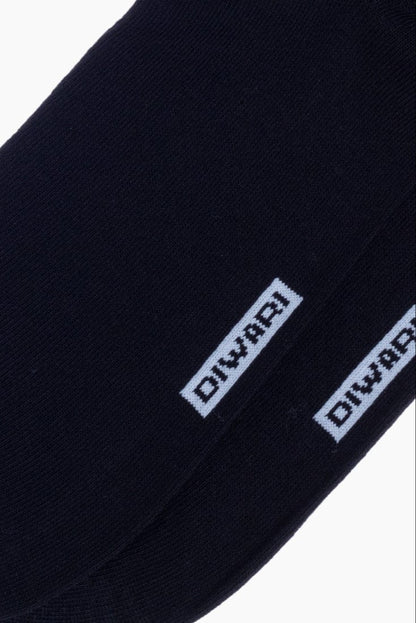 A close-up view of two dark navy blue socks featuring the word DIWARI knitted in light blue lettering.