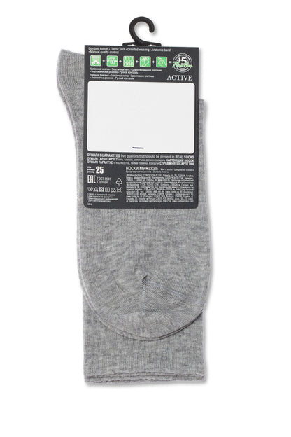 A pair of grey socks hanging from a black plastic hanger against a white background.