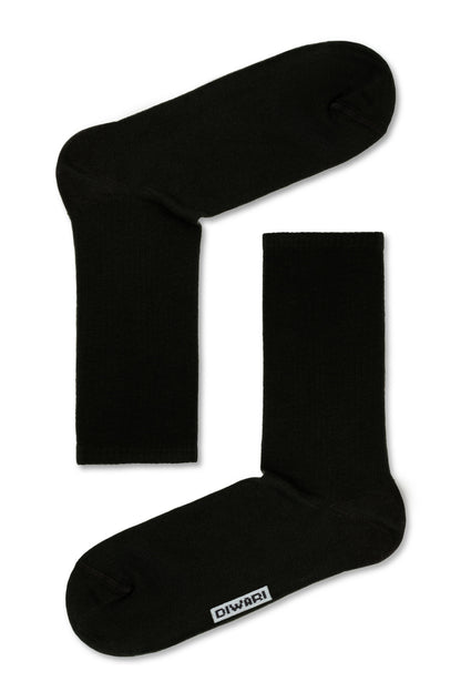 A pair of black crew-length socks featuring a small white rectangular logo patch on the side near the toe.