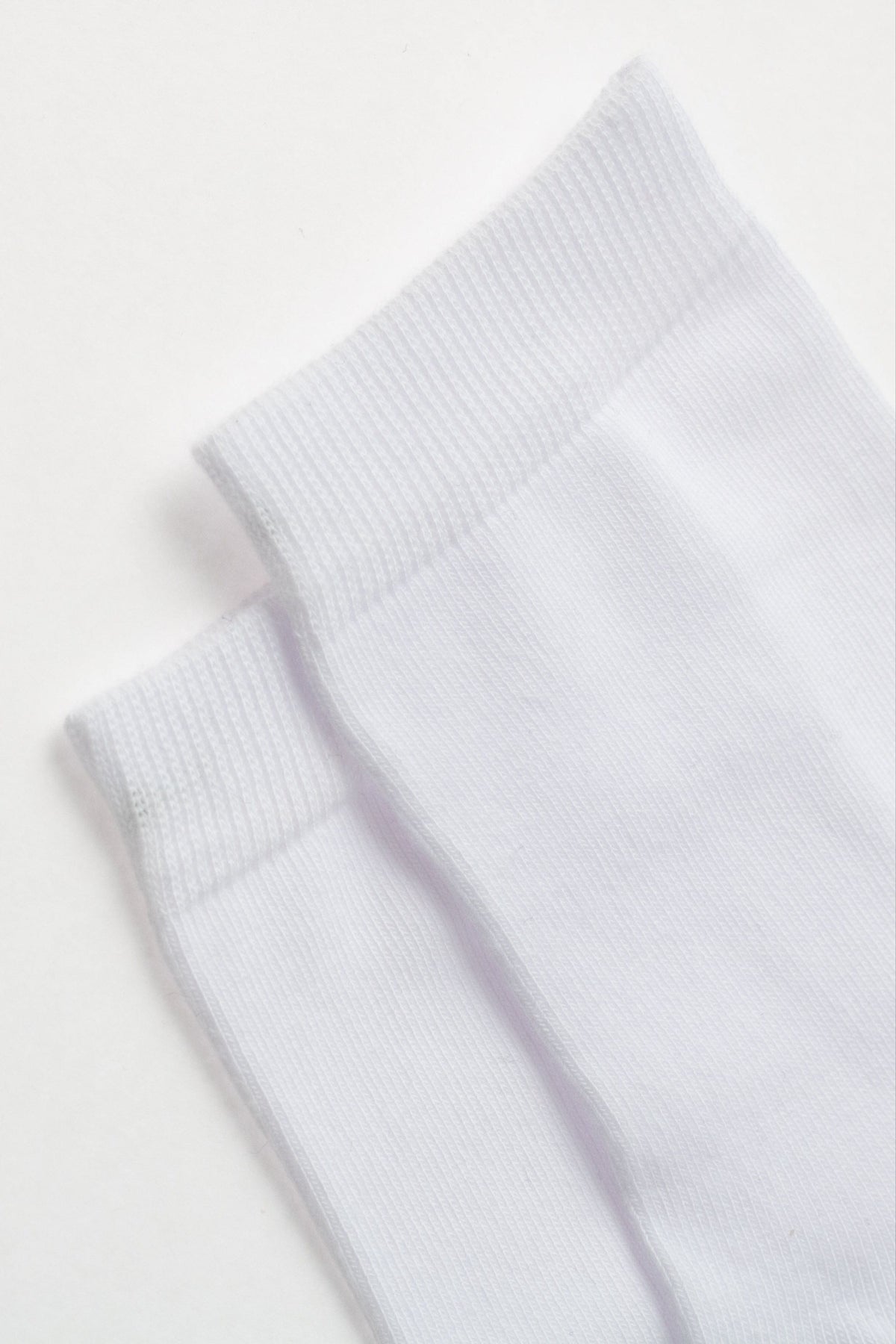 A pair of folded white crew socks shown against a plain white background.