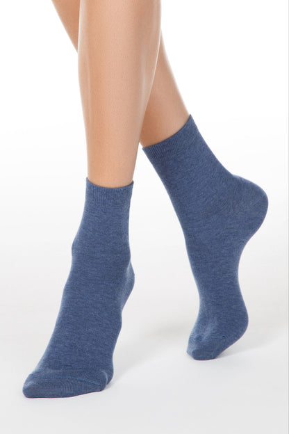 A pair of blue heathered crew socks worn on a person's feet against a plain white background.