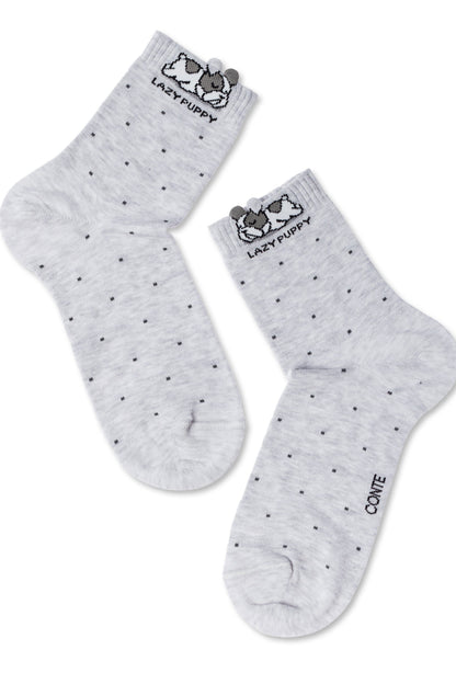 A pair of grey crew socks featuring a repeating dark grey dot pattern, a cute puppy illustration at the cuff, and the text "LAZY PUPPY" stitched below the puppy graphic.