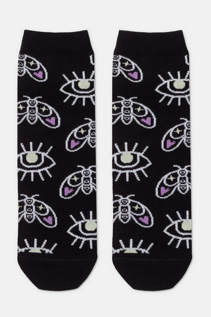 A pair of black crew socks featuring an all-over pattern of white moths with purple accents and stylized white eyes.