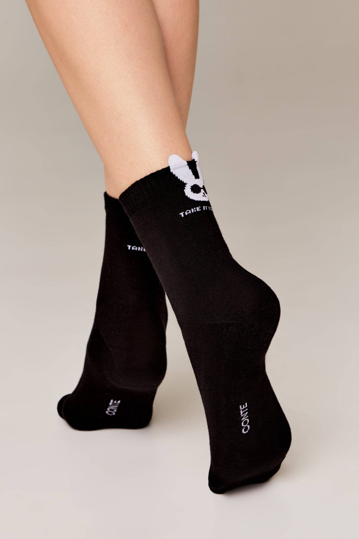 Black socks featuring a white bunny icon on the cuff with text reading "TAKE IT" below it and "CONTE" printed on the back of the heel against a neutral background.