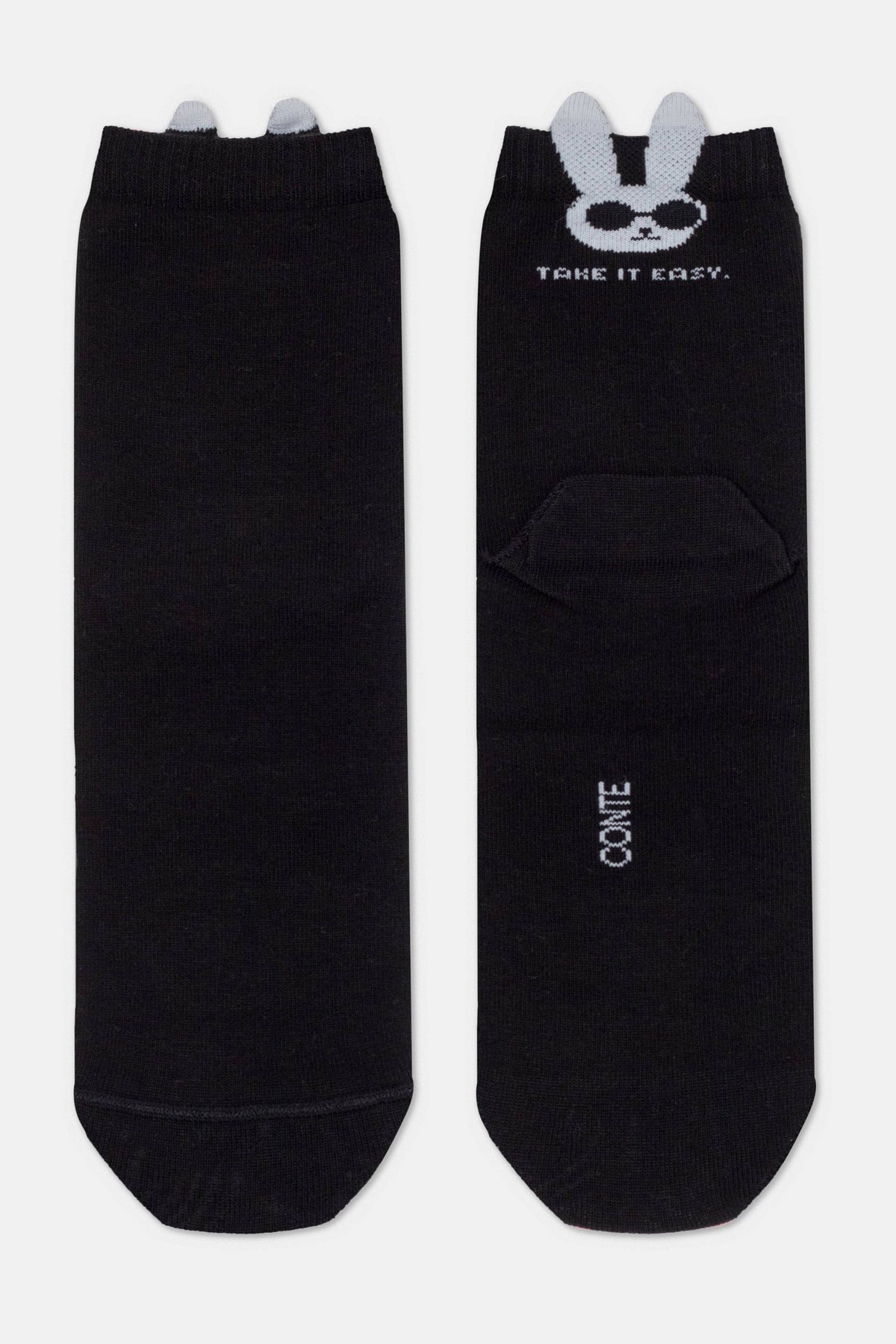 A pair of black ankle socks featuring a white bunny character wearing sunglasses and the text "TAKE IT EASY" printed at the top, with small grey 3D ears extending from the cuffs.
