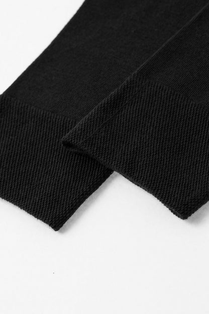 A close-up of two black textile cuffs with a ribbed texture against a plain white background.
