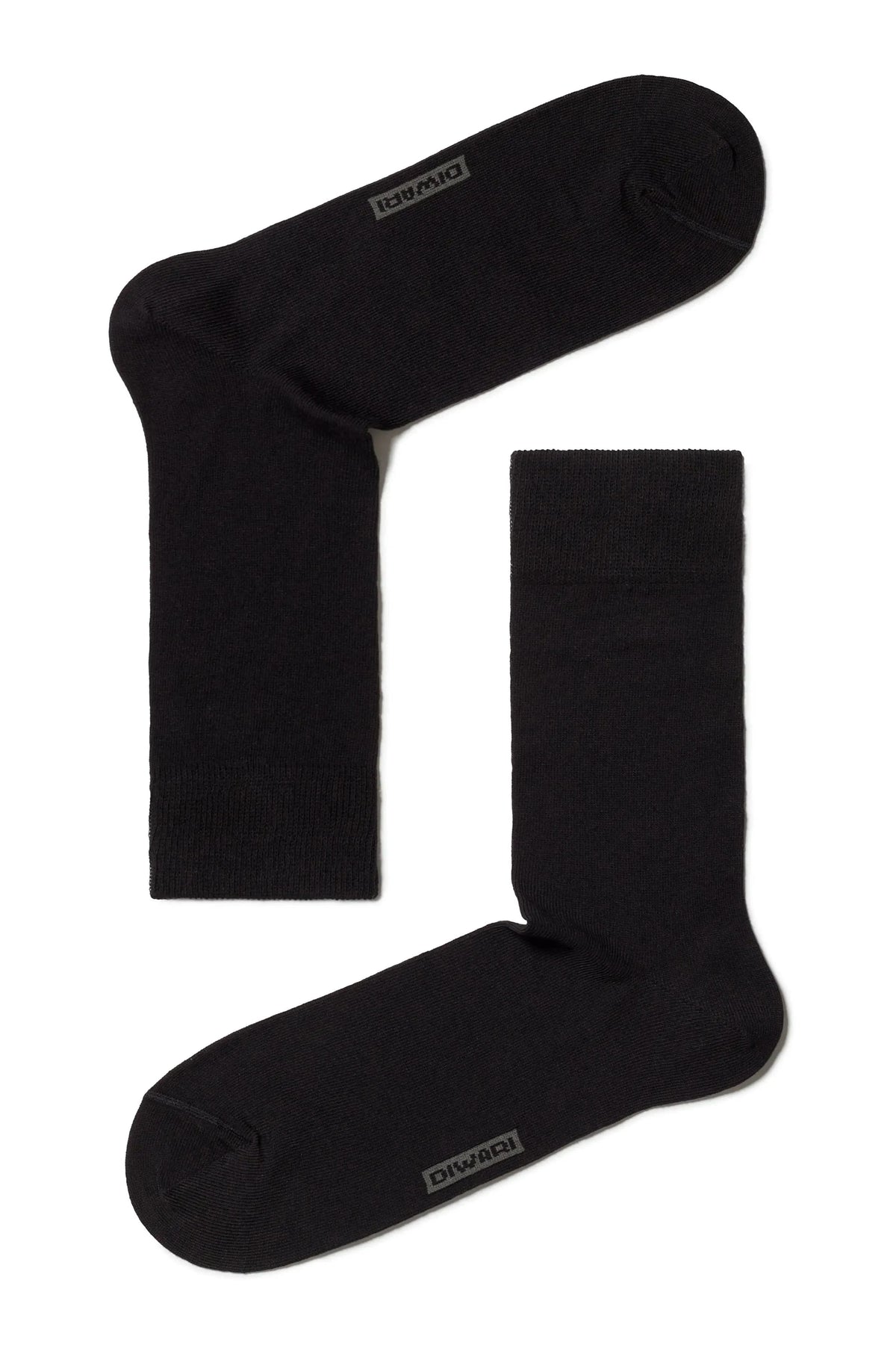 A pair of black crew-length socks laid out flat against a white background, featuring a subtle grey logo on the toe area of each sock.