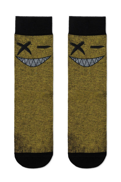 A pair of crew-length socks in a textured mustard yellow, each featuring a black-and-white graphic of a winking face with an x-shaped eye and a wide, toothy grin.