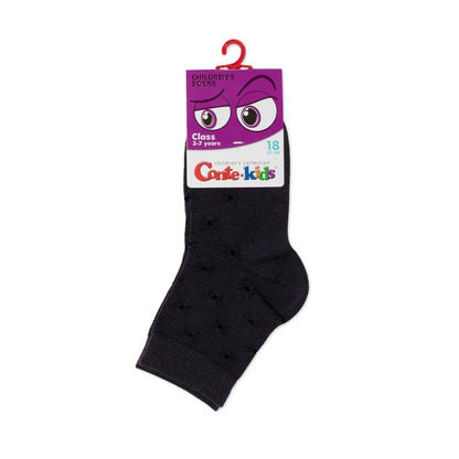 A single dark grey children's sock with a subtle spider pattern hangs from a purple cardboard display header with a cartoon eye graphic.