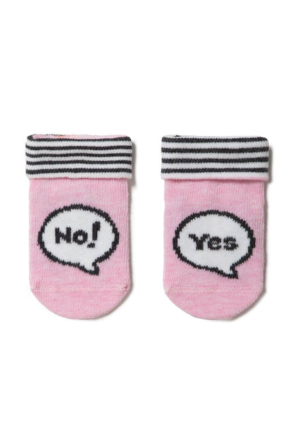 A pair of pink baby socks featuring a black and white striped cuff and a black speech bubble graphic with the text 'No!' on the left sock and 'Yes' on the right sock.
