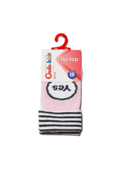 A pair of pink children's socks featuring a white circle with the word Yes printed in black, finished with a black and white striped cuff and a red plastic hanger.