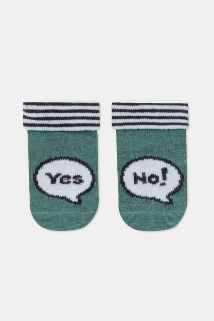 A pair of green socks featuring a speech bubble graphic with the text Yes on the left sock and No on the right sock, finished with a black and white striped ribbed cuff.