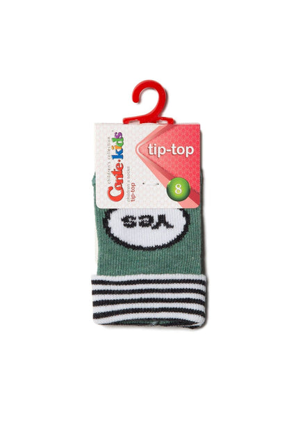 A folded pair of green children's socks with a black and white striped cuff and a graphic patch on the front featuring the word yes inside a white oval.