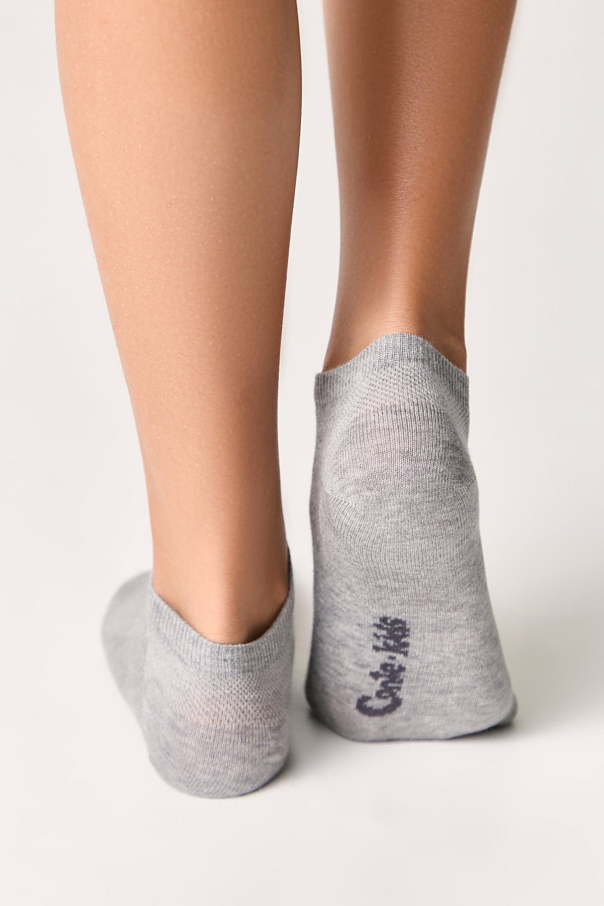 Low-cut ankle socks in light grey worn on a person's feet against a plain white background.