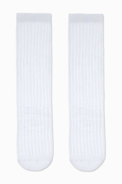 A pair of white, ribbed knee-high socks laid out flat against a plain white background.
