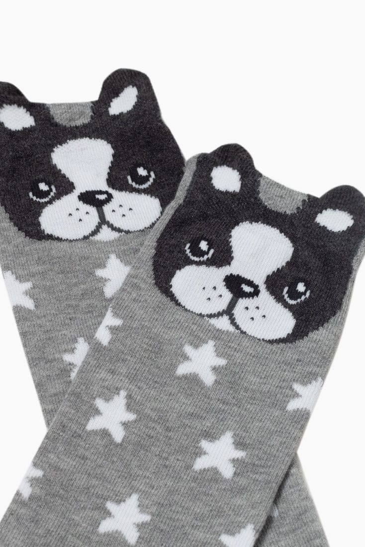 A pair of grey socks patterned with white stars and topped with a cute black and white cartoon dog face design featuring small ears.