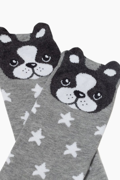 A pair of grey socks patterned with white stars and topped with a cute black and white cartoon dog face design featuring small ears.