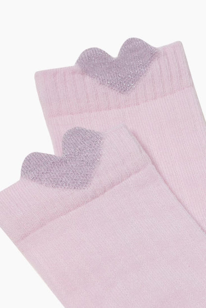 A pair of light pink socks featuring a decorative glittery lilac heart detail on the top cuff of each sock.