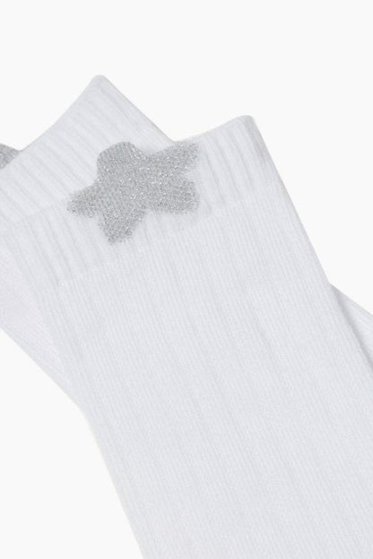 A pair of white ribbed socks featuring a sparkling silver star emblem on the upper side.