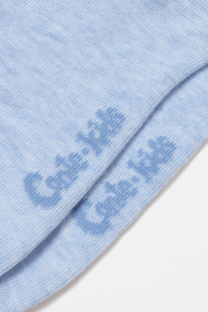 A close-up view of light blue fabric showing the brand name Cale-kids printed in a darker blue font across the bottom of the folded material.