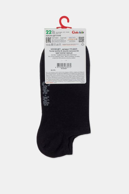A pair of black children's socks connected by a white plastic hanger with a rectangular product information tag attached at the top.