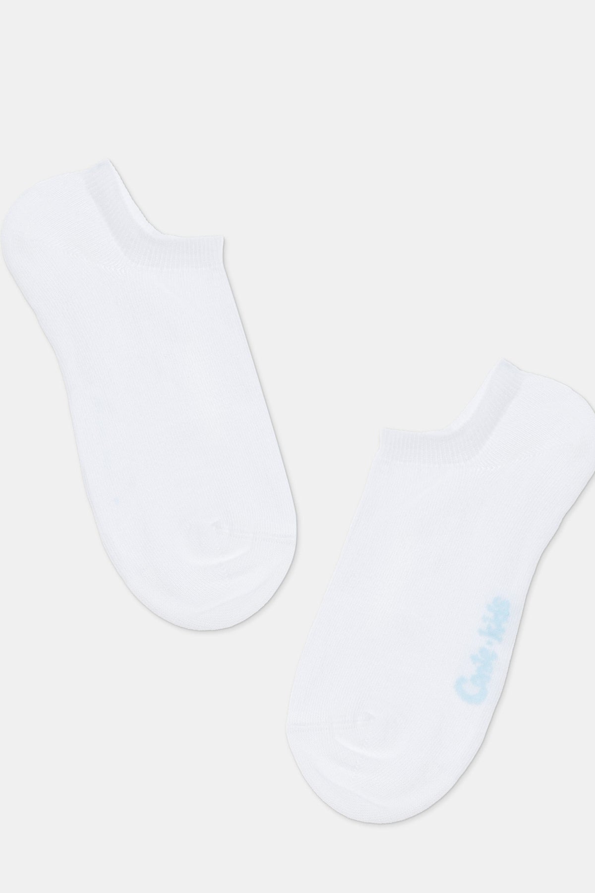 A pair of white ankle socks shown from a top-down view against a light background, with light blue text printed on the side of one sock.