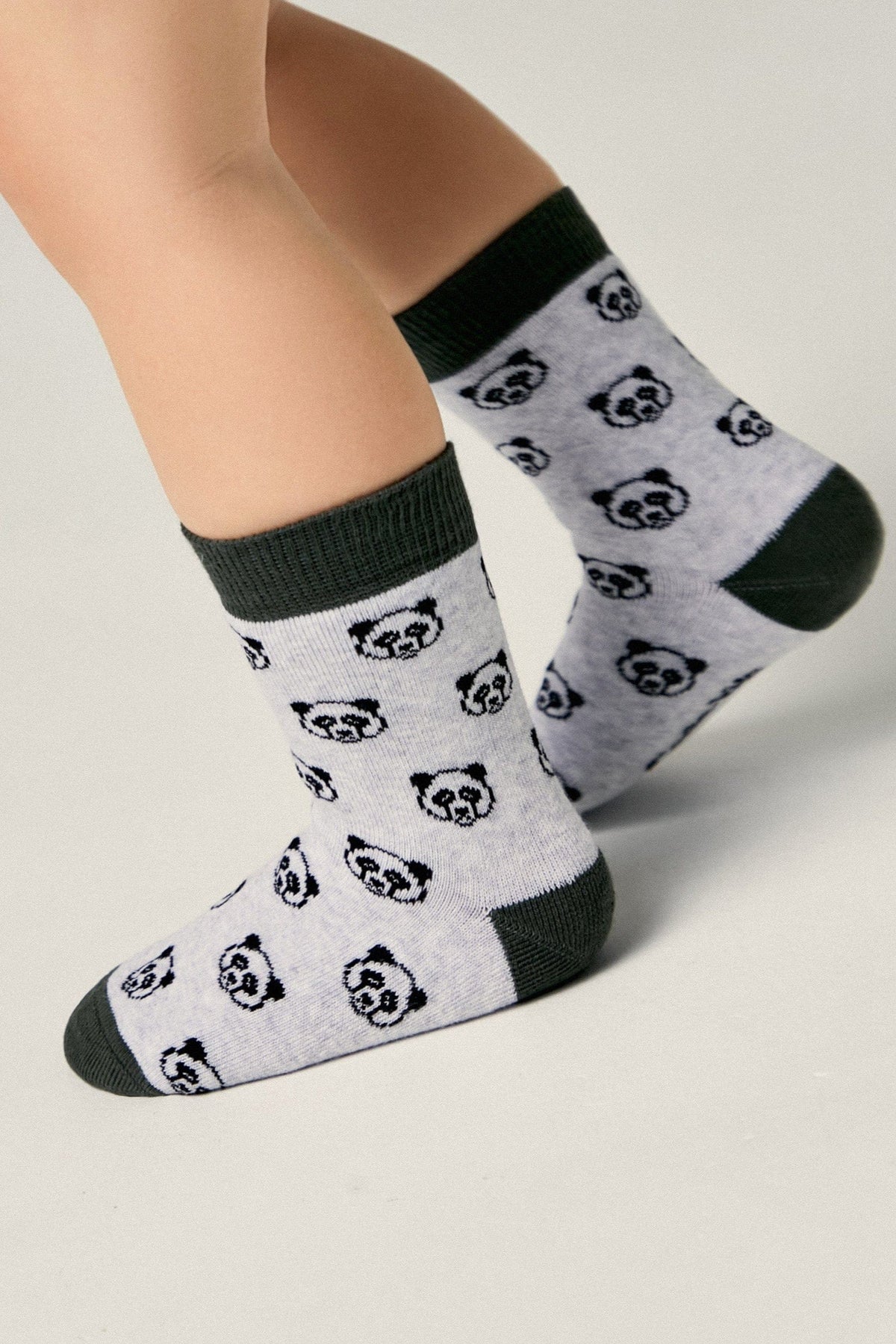 Children's socks in light grey with a repeated black panda face pattern and dark grey cuffs, heels, and toes.