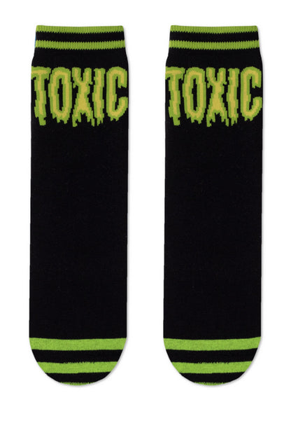 A pair of black ankle socks featuring the word TOXIC in green drippy lettering at the top and lime green horizontal stripes on the cuffs and toe areas.