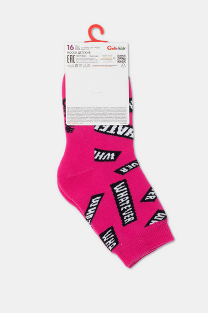 A pair of bright pink children's socks with repeating black and white rectangular logos featuring the text WHATEVER printed all over, displayed on a cardboard hanger.