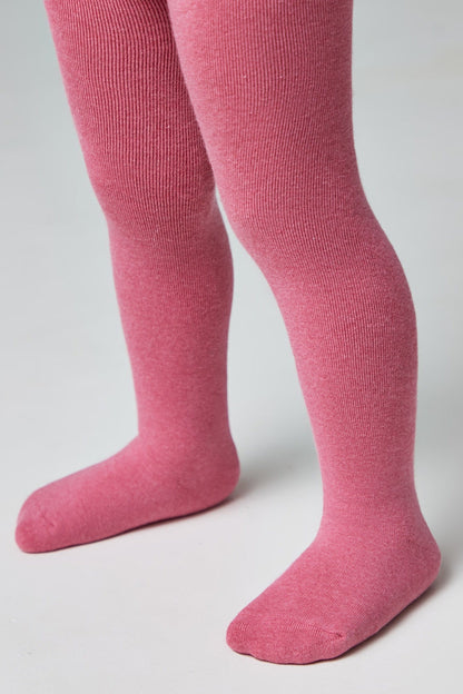 A pair of textured, vibrant pink tights worn on a child's legs against a plain white background.