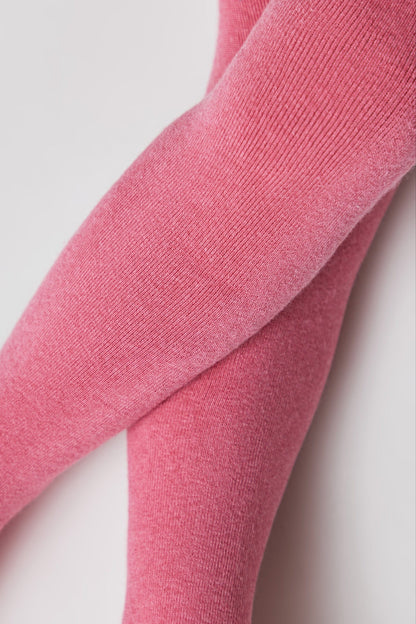 A close-up view of two legs wearing ribbed, heathered pink tights against a plain light background.