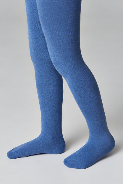 A pair of ribbed tights in a solid medium blue color worn on the lower legs of a person against a plain light gray background.