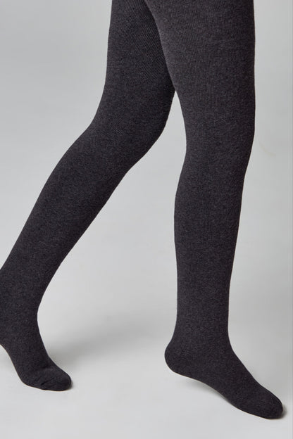 A pair of charcoal grey ribbed tights worn on a person's legs against a neutral grey background.